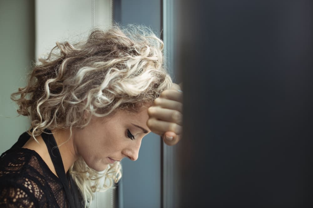 Nachdenkliche Frau am Fenster – Symbolbild für das Loslassen von Perfektionismus und innere Freiheit.